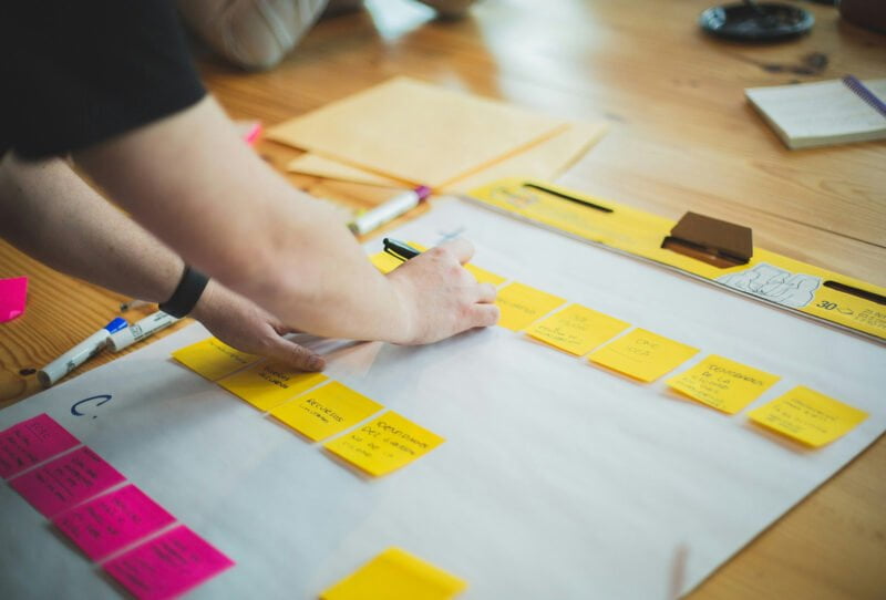 Marketer placing sticky notes on paper